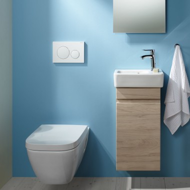 A wall-hung Renova Plan WC and a washbasin area attached to a light blue wall