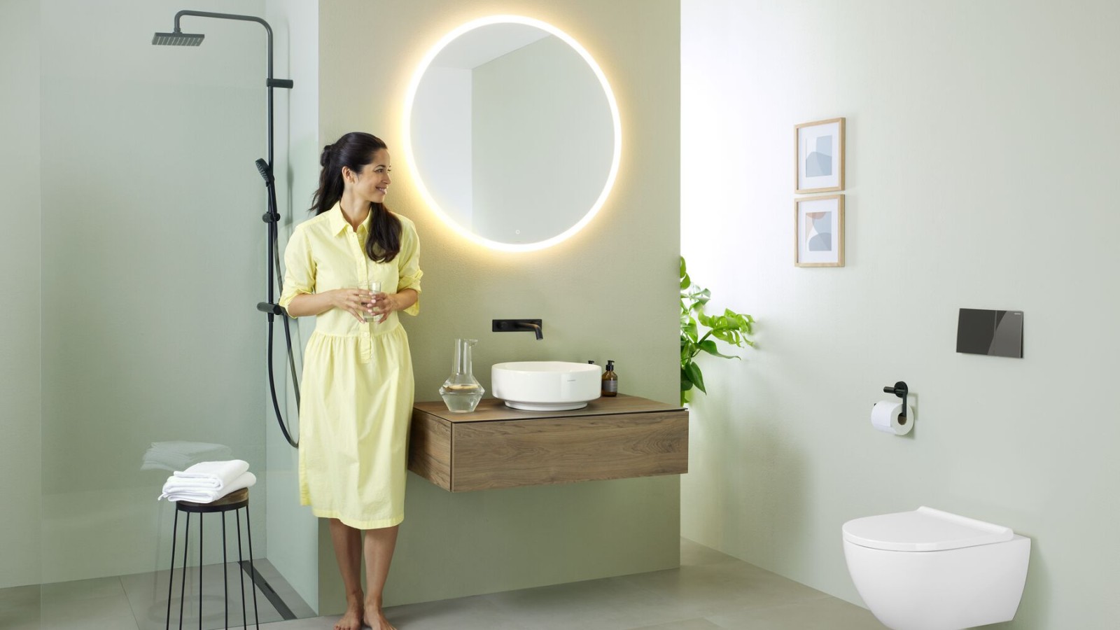 Woman in bathroom featuring a Geberit Option mirror and Geberit VariForm washbasin Woman in bathroom featuring a Geberit Option mirror and Geberit VariForm washbasin