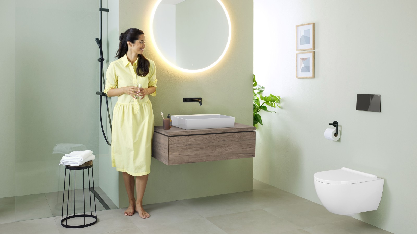 Woman in bathroom featuring a Geberit Option mirror and Geberit VariForm washbasin Woman in bathroom featuring a Geberit Option mirror and Geberit VariForm washbasin