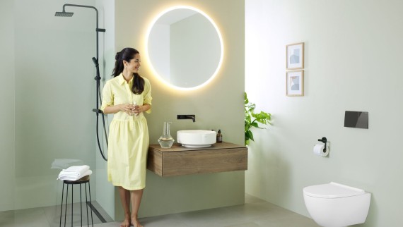 Woman in bathroom featuring a Geberit Option mirror and Geberit VariForm washbasin