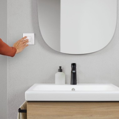 Hand activating light switch in the bathroom (© Geberit)