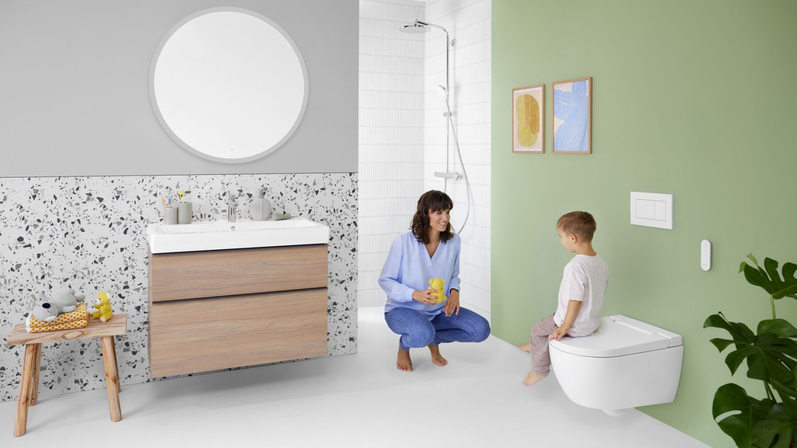Woman and child in modern bathroom with wall-hung shower toilet Geberit AquaClean Alba