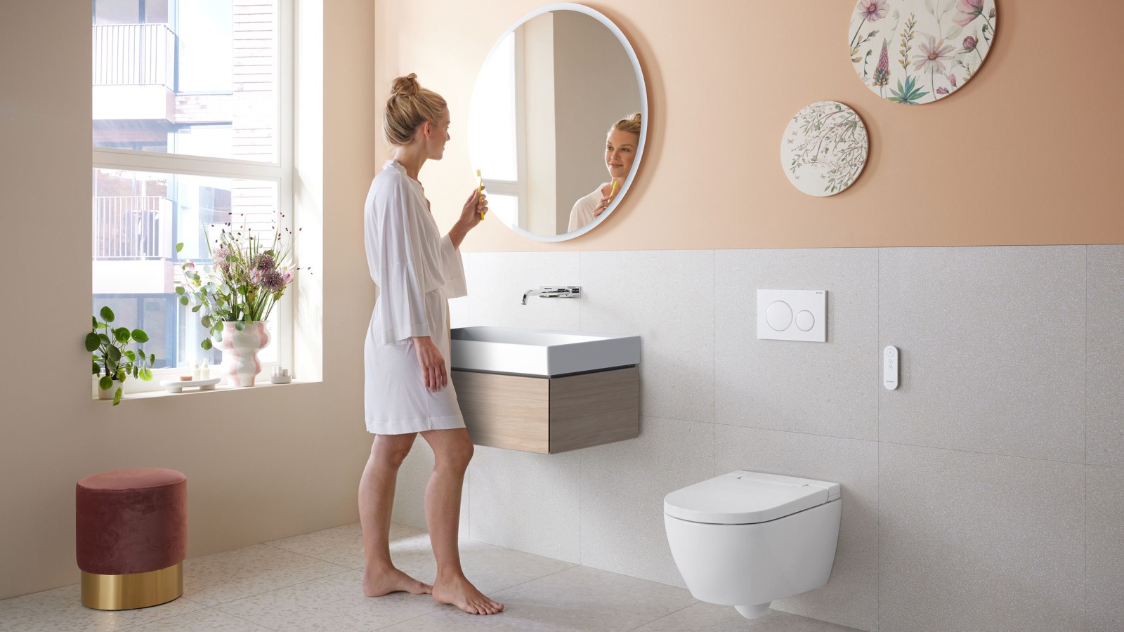 Woman in bathroom with Geberit AquaClean Alba – a cost-effective bidet toilet with spray functionality Woman in bathroom with Geberit AquaClean Alba – a cost-effective bidet toilet with spray functionality