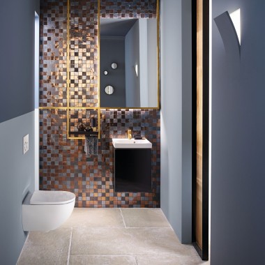 View into a modern guest bathroom with an Acanto WC and an Acanto washbasin in front of a mosaic back panel