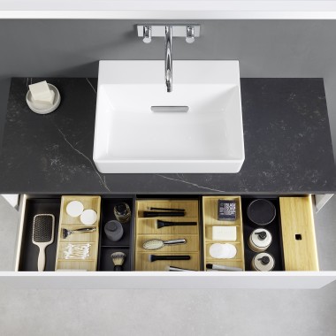 View from above into an open Geberit ONE washbasin drawer with organiser boxes