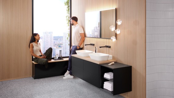 A woman and a man in a large bathroom with Geberit ONE lay-on washbasins, Option mirror and wooden elements A woman and a man in a large bathroom with Geberit ONE lay-on washbasins, Option mirror and wooden elements