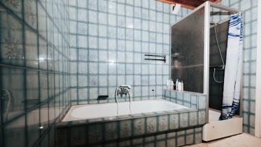 Bathroom with blue tiles, shower cubicle and bathtub