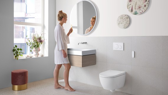 Woman in white bathroom with ceramic appliances and bathroom furniture Woman in white bathroom with ceramic appliances and bathroom furniture