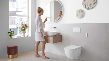 Woman in white bathroom with ceramic appliances and bathroom furniture