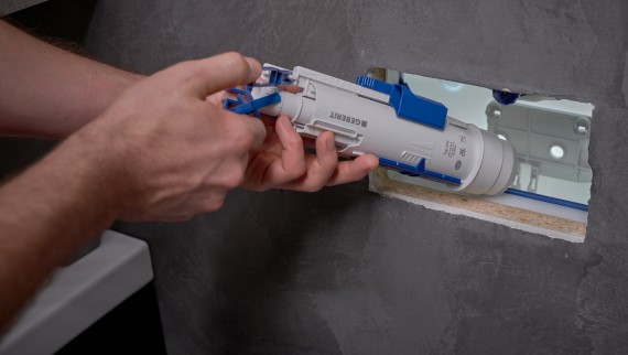 A man installs a Geberit flush valve in a concealed cistern (© Ben Huggler) A man installs a Geberit flush valve in a concealed cistern (© Ben Huggler)