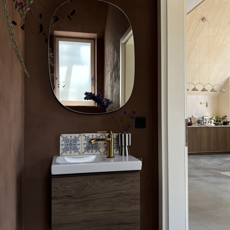 Wood runs as a design element throughout the house. The Geberit iCon washbasin cabinet in walnut hickory stylishly ties the rooms together (© Büşra Qadir)