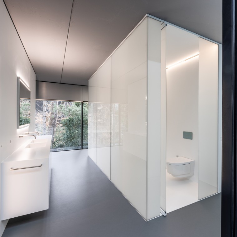The bathroom was added as a “separate piece of furniture” to the steel and glass structure (© Lucas van der Wee)